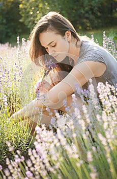 The girl sit in the middle of a lavender field