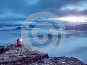 Girl sit on rock in  darkess holding in hands symbol of hope