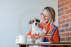 Girl sititng at table with computer and dog