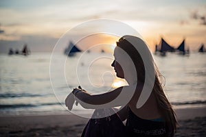 A girl sits on the beach on the island of Boracay