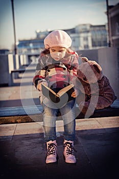 Girl sits on a bench and reads the book