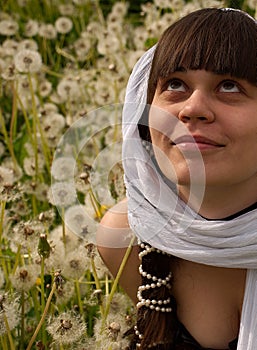 A girl sits in a field and enjoying the summer