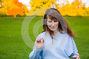 the girl sits on the field and the wind blows her hair