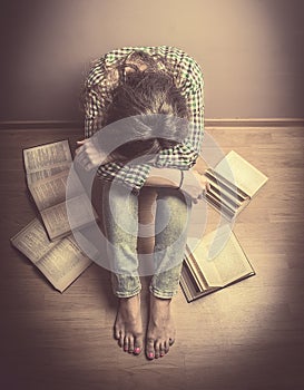 Girl sits on the floor with his head resting on his knees around it laid open the book, Study tired, student, retro toning