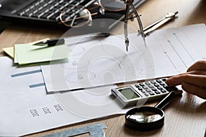 The girl sits at her desk and draws up graphs and histograms about income, business and finance, planning , economics