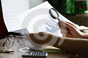 The girl sits at her desk and draws up graphs and histograms about income, business and finance, planning , economics