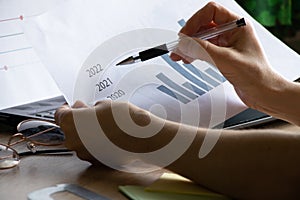 The girl sits at her desk and draws up graphs and histograms about income, business and finance, planning , economics