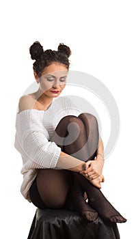 A girl sits hugging her knees