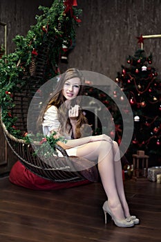 Girl sits idle relax in lounge during the celebration of Christmas and New Year with Christmas tree