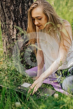 girl sits outdoors and works at a laptop. freelance. selfeducation. the concept of remote learning and outdoor work. photo