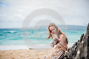 A girl sits on a rock on the beach of Boracay