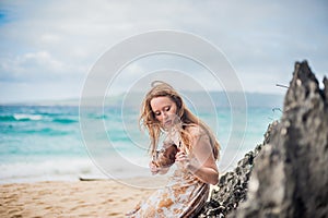 A girl sits on a rock on the beach of Boracay