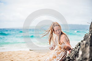 A girl sits on a rock on the beach of Boracay