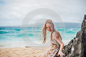 A girl sits on a rock on the beach of Boracay