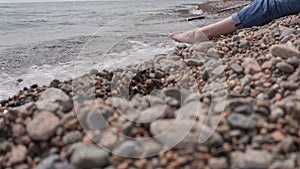 Girl sits on the shore of Baikal.