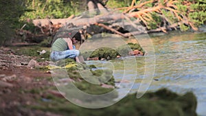 Girl sits on the shore of Baikal.