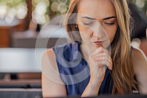 a girl sits on a summer terrace and works at a laptop. freelance. selfeducation. the concept of remote learning and photo