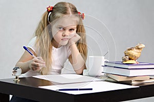 The girl writes on a piece of paper sitting at the table in the image of the writer