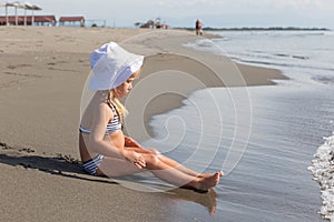 Girl sits at the water's edge