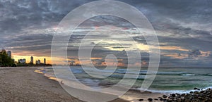 Girl sitting along on beach at sunset