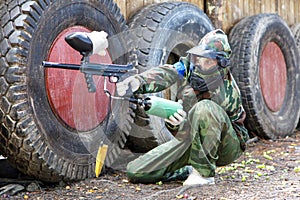 Girl sitting in ambush on paintball