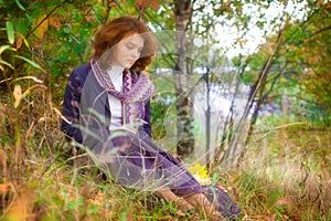 Girl sitting on autumn grass