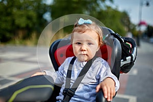 Girl sitting in a baby bike seat of a bicycle of her father safety emotions anxiety kids children parenting.