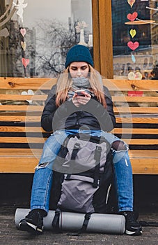 Girl sitting on a banch and using a phone