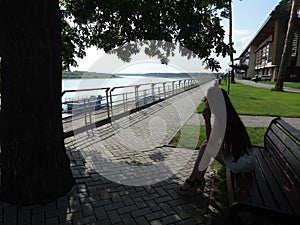 Girl sitting on the bank of the river