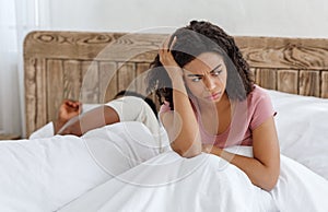 Girl sitting in bed, cant sleep because of snoring partner