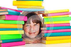 Girl sitting behind pile of books