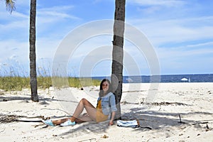 Girl sitting bellow the palm tree