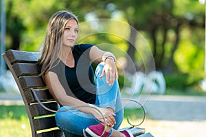 Girl sitting on a bench in the park, close-up