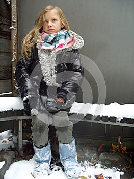 Girl is sitting on a bench in a winter'
