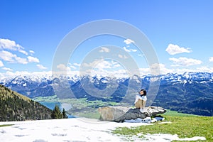 Girl sitting on big rock, Schafberg mountain, Austria