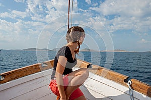 Girl sitting on the bow of the ship