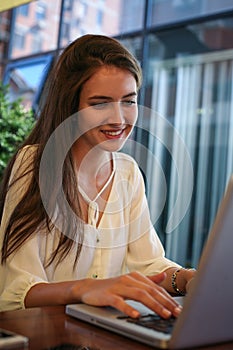 Girl sitting at cafe text mails.