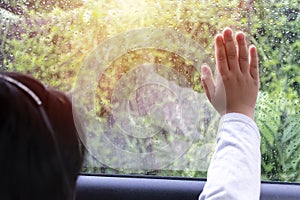 Girl sitting in the car. Hands on the car glass