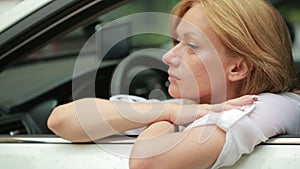 Girl sitting in the car in the rain. the driver waits for passengers