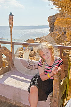 Girl sitting on a carved wooden bench