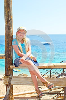 Girl sitting on a carved wooden bench