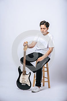 Girl sitting on a chair and holding a guitar