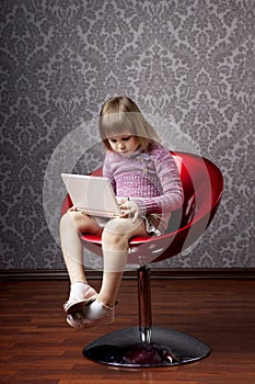 Girl sitting in a chair with a laptop