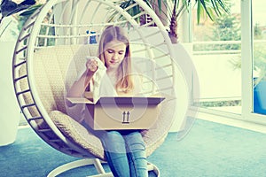 Girl sitting in chair and opening a package