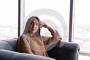 Girl sitting in a chair by the window on a winter day