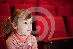 Girl sitting at cinema, steadfastly looking