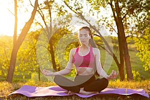 Girl is sitting with closed eyes on a soft rug.