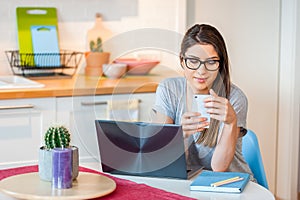 Girl sitting confortable at home using modern technology photo