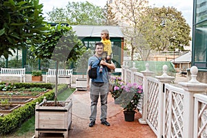 Girl sitting on Daddy shoulders in garden
