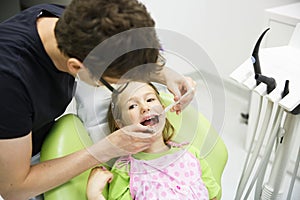 Girl sitting on dental chair on her regular dental checkup